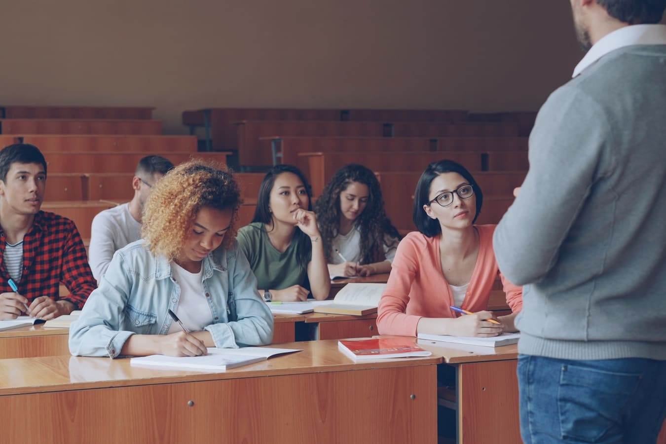 A lecturer speaking to students in a university lecture hall